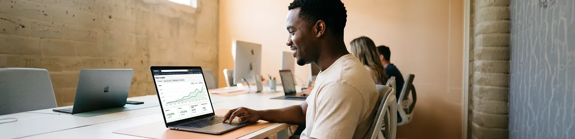 Ecommerce seller reviewing a now-optimized Amazon brand store with rising performance metrics on laptop screen Ecommerce seller reviewing a now-optimized Amazon brand store with rising performance metrics on laptop screen