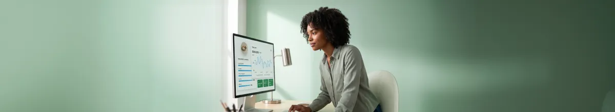 Shopify brand owner reviewing a unified Shopify and Amazon analytics dashboard with healthy growing metrics at desk Shopify brand owner reviewing a unified Shopify and Amazon analytics dashboard with healthy growing metrics at desk