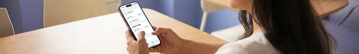 Person using iOS app on iPhone showing engaging content feed with natural ambient light in over-the-shoulder shot with bright app screen visible Person using iOS app on iPhone showing engaging content feed with natural ambient light in over-the-shoulder shot with bright app screen visible