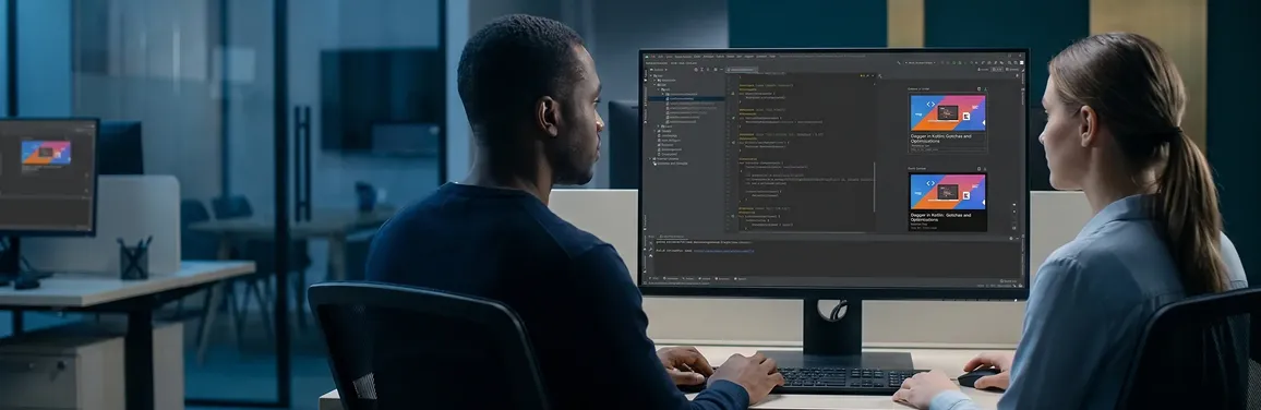 Android app development team reviewing live app build on large screens, blue-tinted office light, backs to camera Android app development team reviewing live app build on large screens, blue-tinted office light, backs to camera
