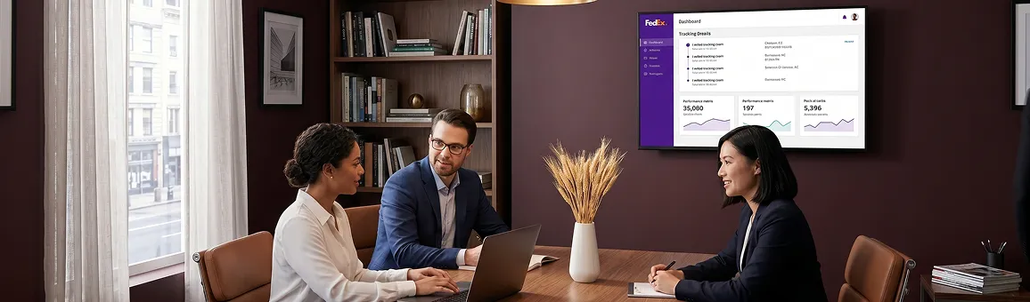 Eyeglasses brand ecommerce operations team gathered around a screen showing live FedEx tracking events, natural daylight Eyeglasses brand ecommerce operations team gathered around a screen showing live FedEx tracking events, natural daylight