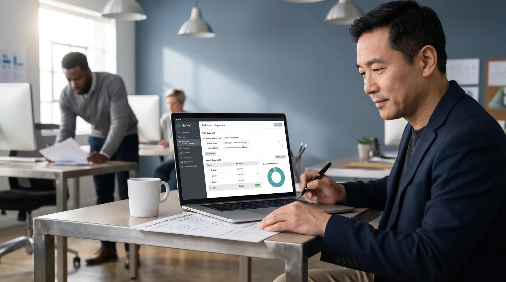 Senior Klaviyo strategist annotating a segmentation plan in a notebook next to a laptop showing the Klaviyo segment builder Senior Klaviyo strategist annotating a segmentation plan in a notebook next to a laptop showing the Klaviyo segment builder
